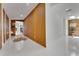 Hallway with decorative wood paneling, bright lighting, and a glimpse of the living area at 1700 Lake Markham Rd, Sanford, FL 32771