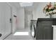 Light-filled laundry room features tile flooring, modern washer/dryer, and skylight at 1700 Lake Markham Rd, Sanford, FL 32771