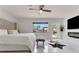 Bright main bedroom with ceiling fan, white tile floors, access to the deck, and a modern fireplace at 1700 Lake Markham Rd, Sanford, FL 32771