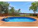 A sparkling in-ground pool surrounded by a wooden deck and tropical foliage at 1700 Lake Markham Rd, Sanford, FL 32771