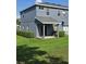Spacious backyard featuring a covered patio, lush green grass, and mature shrubs at 1754 Fritwell Ct, Ocoee, FL 34761