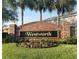 Welcoming Wentworth community sign surrounded by flowers and palm trees at 1754 Fritwell Ct, Ocoee, FL 34761