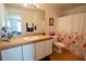 The bathroom has a single sink, a mirror, a toilet, and a shower with a floral curtain at 1858 Snapper Dr, Poinciana, FL 34759