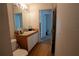 A small functional bathroom with a single sink, a large mirror and an adjoining room at 1858 Snapper Dr, Poinciana, FL 34759