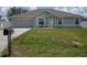 Charming single-story home featuring a well-maintained lawn, attached garage, and welcoming front entrance at 1858 Snapper Dr, Poinciana, FL 34759