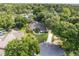 Aerial view of the home with lush green landscaping and a long driveway at 1947 Broadleaf Ct, Windermere, FL 34786