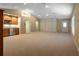 Large basement area with carpet and a built-in wet bar and custom cabinets at 1947 Broadleaf Ct, Windermere, FL 34786