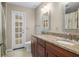 Bathroom featuring dual sinks with granite counters and a door that leads to a sunroom at 1947 Broadleaf Ct, Windermere, FL 34786