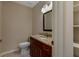 Bathroom featuring a granite countertop vanity, toilet, and built-in shelving at 1947 Broadleaf Ct, Windermere, FL 34786