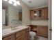 Bathroom with vanity, toilet, and wooden storage cabinets for ample storage space at 1947 Broadleaf Ct, Windermere, FL 34786
