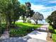 Beautiful community view featuring a lush lawn, mature trees, lake access, and gated entry at 1947 Broadleaf Ct, Windermere, FL 34786