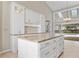 Open kitchen with granite countertops, island, stainless appliances, tile floors and white cabinets at 1947 Broadleaf Ct, Windermere, FL 34786