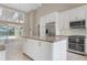 Open kitchen with granite countertops, stainless appliances, tile floors, island and white cabinets at 1947 Broadleaf Ct, Windermere, FL 34786