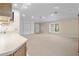 Bright, neutral living room with large window, carpet, and white storage cabinets at 1947 Broadleaf Ct, Windermere, FL 34786