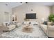 Living room with vaulted ceilings decorated with arm chairs, a sofa, tv and coffee table on patterned rug at 1947 Broadleaf Ct, Windermere, FL 34786