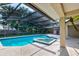Sparkling blue pool and hot tub with screened enclosure and view of lush green landscape at 1947 Broadleaf Ct, Windermere, FL 34786