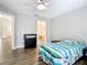 A cozy bedroom with hardwood floors, a fan, and a bathroom at 2124 Fish Eagle St, Clermont, FL 34714
