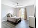 Cozy bedroom featuring a large window, ceiling fan, and light gray walls at 2124 Fish Eagle St, Clermont, FL 34714