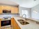 Bright kitchen features modern stainless steel appliances, wood cabinets, and stone countertops at 2124 Fish Eagle St, Clermont, FL 34714