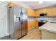 View of the kitchen that includes stainless steel fridge, gray backsplash and wood floors at 2124 Fish Eagle St, Clermont, FL 34714