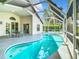 A refreshing kidney-shaped pool with clear blue water is surrounded by a screened enclosure and concrete patio at 2124 Fish Eagle St, Clermont, FL 34714
