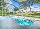 A refreshing kidney-shaped pool with clear blue water is surrounded by a screened enclosure and concrete patio at 2124 Fish Eagle St, Clermont, FL 34714