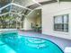 A refreshing kidney-shaped pool with clear blue water is surrounded by a screened enclosure and concrete patio at 2124 Fish Eagle St, Clermont, FL 34714