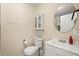 Half bathroom featuring a toilet, vanity with a sink, and a medicine cabinet with glass doors at 214 Majors Ln # C, Kissimmee, FL 34743