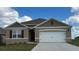 Charming single-story home featuring a two-car garage, neutral paint, and beautifully manicured lawn at 2212 Albatross Nest Dr, Bartow, FL 33830