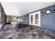 Covered patio with tile flooring, a stylish blue wall, outdoor decor, and double doors at 2420 Kerridale St, Deltona, FL 32738
