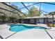 Backyard pool enclosed by a screened-in patio, with clear blue water and surrounding greenery at 2420 Kerridale St, Deltona, FL 32738