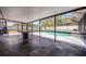 Large screened pool area with dark tile flooring, a table, and a view of the inviting pool at 2420 Kerridale St, Deltona, FL 32738