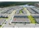 Aerial view of a community of townhomes with a lake and trees in the background at 2439 Dubai St, Kissimmee, FL 34747