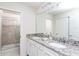 Elegant bathroom featuring double sinks, granite countertops, and a glass-enclosed shower at 2439 Dubai St, Kissimmee, FL 34747