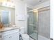Bathroom featuring granite counter tops, white cabinets and a glass door shower at 2439 Dubai St, Kissimmee, FL 34747