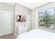 Serene bedroom with a window view, features neutral tones, mounted TV, and ample closet space at 2439 Dubai St, Kissimmee, FL 34747