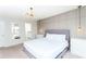 Inviting bedroom with modern lighting, a gray paneled accent wall, and ensuite bathroom access at 2439 Dubai St, Kissimmee, FL 34747