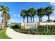 Community entrance sign, 'Windsor at Westside' beautifully landscaped with mature palm trees and lush greenery at 2439 Dubai St, Kissimmee, FL 34747