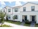 Inviting townhome with a bright white exterior, gray trim, and colorful landscaping at 2439 Dubai St, Kissimmee, FL 34747