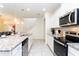 Modern kitchen with granite countertops, stainless appliances, and an open view of dining area and staircase at 2439 Dubai St, Kissimmee, FL 34747