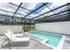 Relaxing pool area with lounge chairs and covered screen for shade and privacy at 2439 Dubai St, Kissimmee, FL 34747