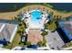 Aerial view of the community pool, featuring a unique shape, lounge chairs and tropical landscaping at 2439 Dubai St, Kissimmee, FL 34747