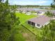 Backyard aerial view of home with a screened in porch, landscaping and a lake in the distance at 2479 Pine Preserve Ct, St Cloud, FL 34771