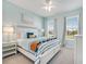 Bright bedroom with light blue walls, white trim, a white bed and two windows with curtains at 2479 Pine Preserve Ct, St Cloud, FL 34771