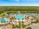 Aerial view of a luxury community pool with palm trees and abundant seating, creating a resort atmosphere at 2479 Pine Preserve Ct, St Cloud, FL 34771