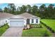 Charming single-story home featuring a two-car garage, brick driveway, manicured lawn and lovely landscaping at 2479 Pine Preserve Ct, St Cloud, FL 34771