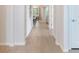 Long hallway with wood-look floors leading to a dining area and kitchen, freshly painted in neutral colors at 2479 Pine Preserve Ct, St Cloud, FL 34771