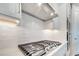 Close up of modern stainless steel range, vent hood, and backsplash in a well-appointed kitchen at 2479 Pine Preserve Ct, St Cloud, FL 34771