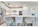 Elegant kitchen island with barstool seating, stainless steel appliances, and stylish white cabinets at 2479 Pine Preserve Ct, St Cloud, FL 34771