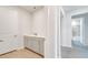 Bright mud room with white cabinets, a sink, light wood flooring and a view into the hallway at 2479 Pine Preserve Ct, St Cloud, FL 34771